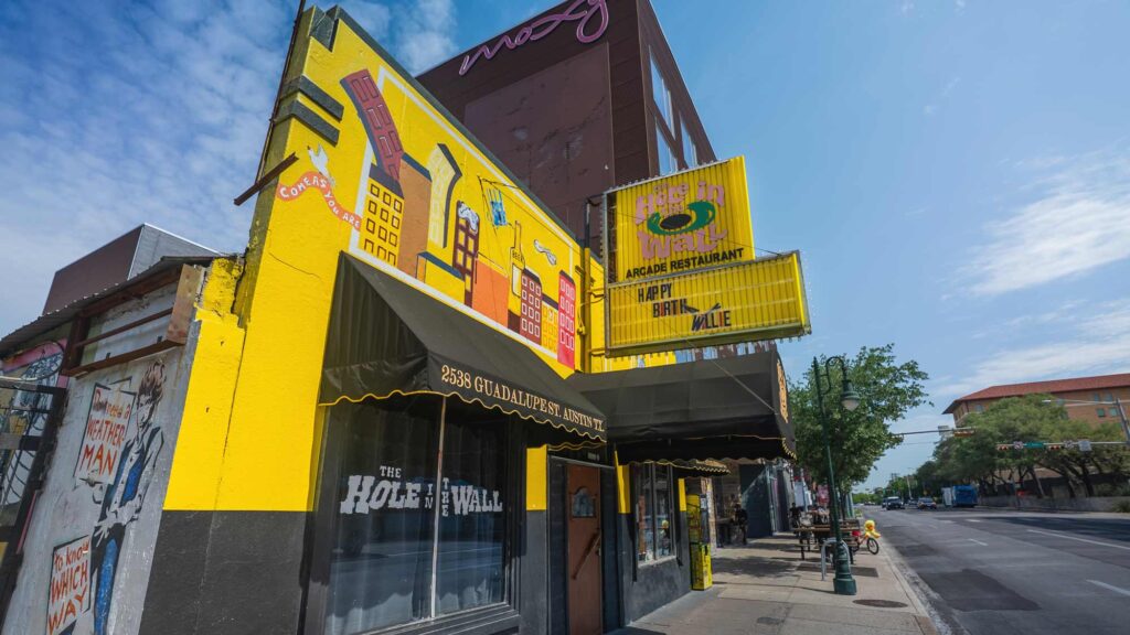 a photo showing the front entrance and sign for music venue, Hole in the Wall Austin, TX